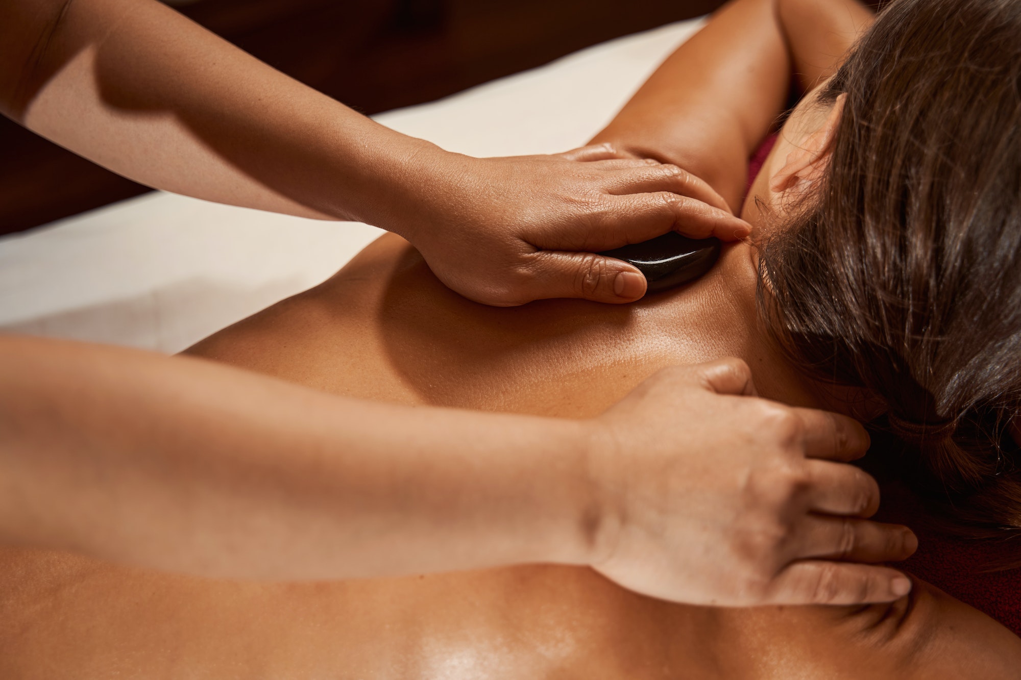 Wellness center client receiving hot stone massage
