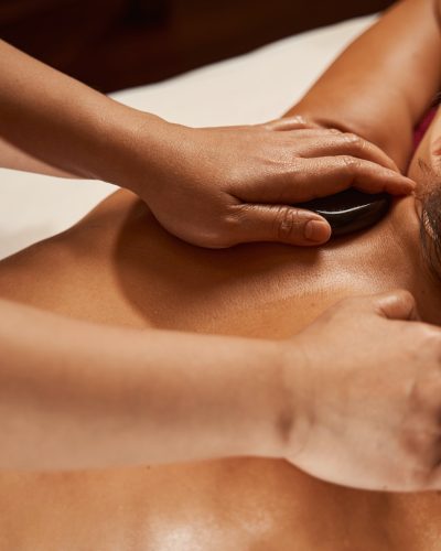 Wellness center client receiving hot stone massage